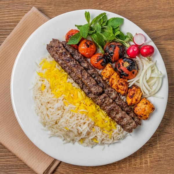 A white plate with two skewers of grilled meat, rice, roasted tomatoes, radishes, and mint.
